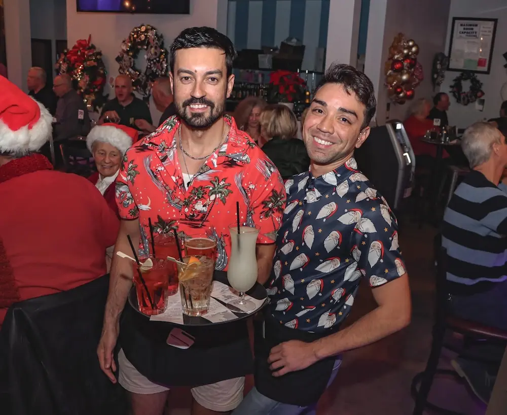 Two staff members at the Roost posing with a tray of drinks.